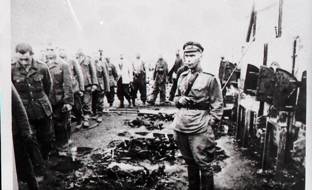 Príslušník Červenej armády sleduje odvádzanie zajatých nemeckých vojakov po oslobodení tábora Auschwitz-Birkenau