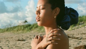 Zmena: Pôvabná modelka zahalená v slnečných lúčoch pri mori