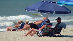 Tragédia na pláži: Žena po zrážke uviazla pod kolesami policajného auta