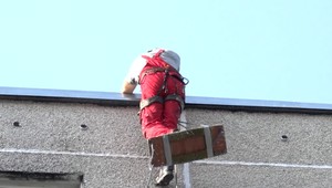 Pracovník bol vo výške 12. poschodia, keď sa vyklonil muž z okna a vyhrážal sa prerezaním lana