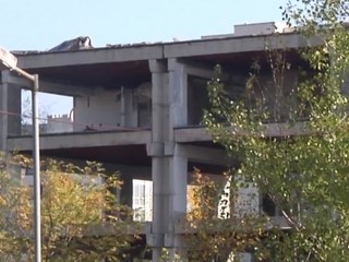 Na streche budovy sa objavujú ľudia, sú medzi nimi aj deti