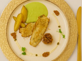 Pstruh na bylinkách s pečenými zemiakmi, hráškovým pyré a krémom z pečeného cesnaku