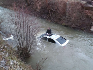 Dvadsaťročný vodič po šmyku skončil s autom v rieke. Na záchranárov čakal na streche