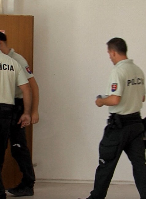 policajti kráčajú za obvinenými 