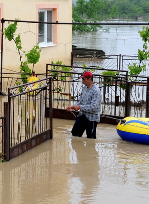muz pred domom, nafukovaci cln, povodne zaplavy, nizny zipov v okrese trebisov