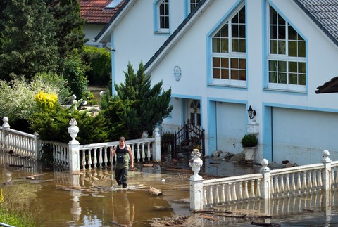 Nemecko záplavy muž pred domom upratuje