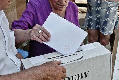 Volebná urna, obálka, ruky