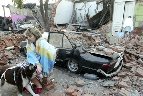 Žena sedí v troskách domu v čilskom meste Talca