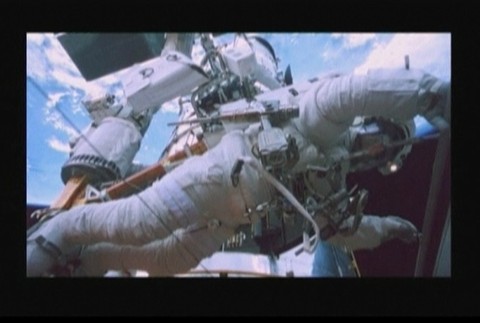 kozmonaut vo vesmire v pozadi raketa