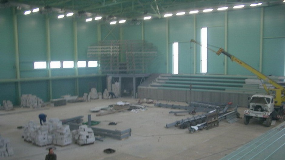 Ľudia pracujú na výstvbe špotovej haly