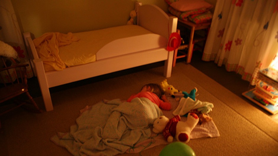 dievcatko lezi zakryte na zemi v detskej izbe, spi