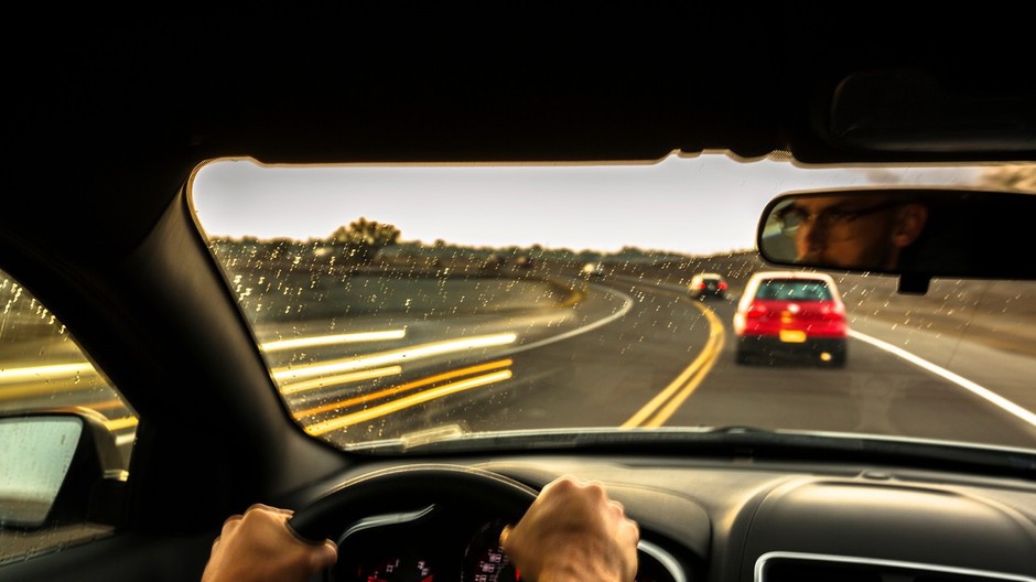 muž za volantom v aute cesta ilustračná