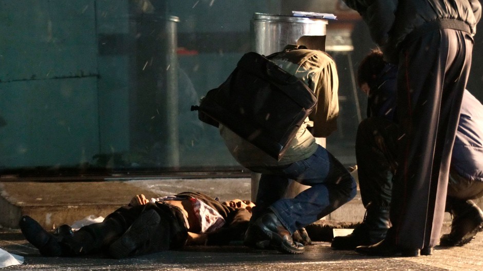 Vyšetrovatelia na mieste výbuchu pri jednej z obetí...