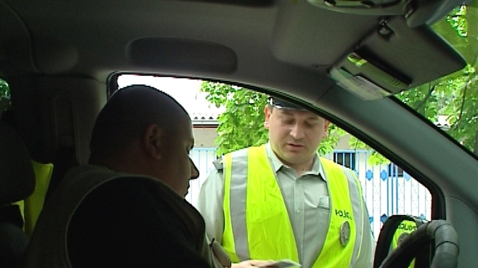 Vodič dáva policajtovi vodičský preukaz
