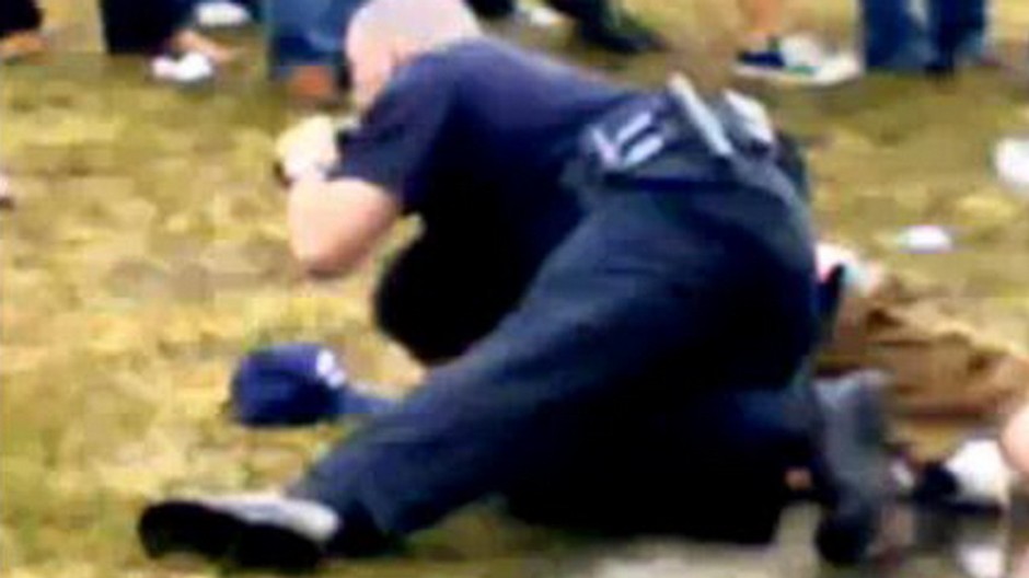 policajt bije na zemi muza