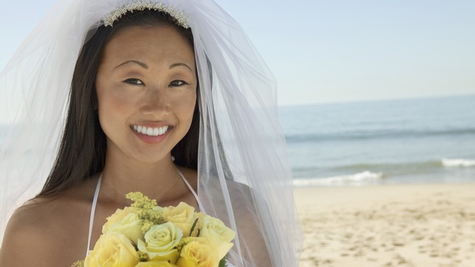 Žena v svadobných šatách na pláži