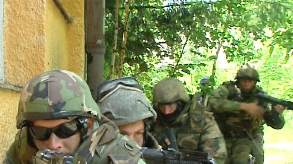 Vojaci pod oknom budovy so samopalmi akože akcia