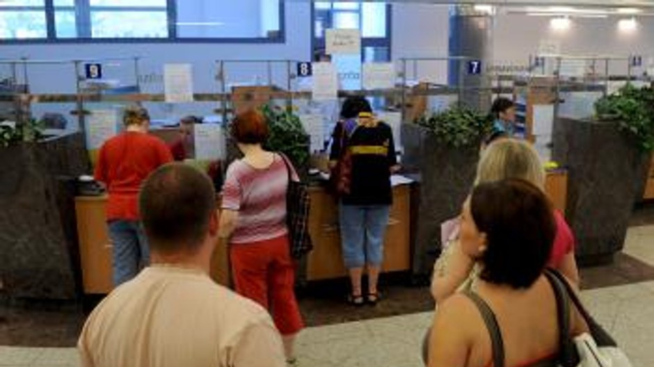 ludia stoja v poistovni pred prepazkami, cakaju na vybavenie