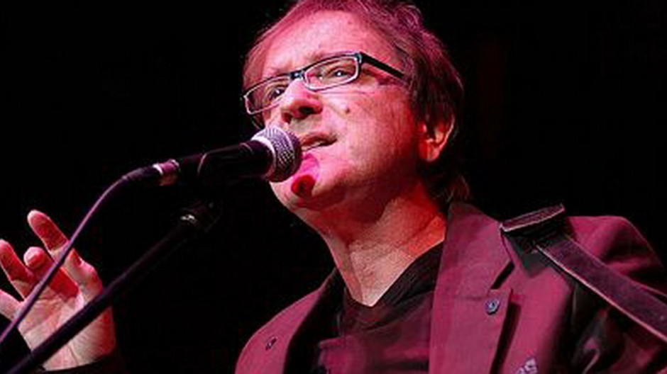 Miroslav Žbirka s gitarou na čiernom pozadí