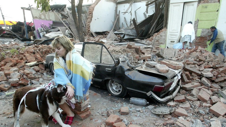 Žena sedí v troskách domu v čilskom meste Talca