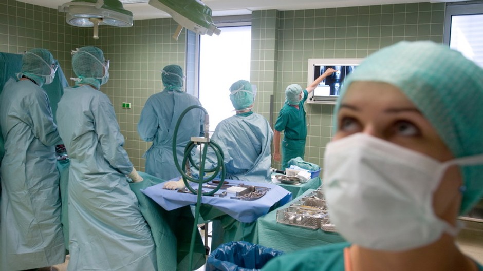 Sestrička a lekári na sále, pozerajú si rontgen