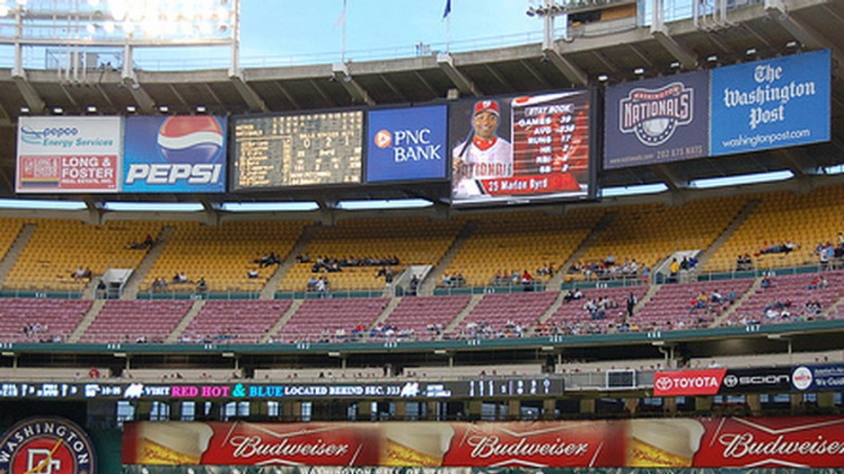 futbalovy stadion, niekolko fanusikov, reklamy