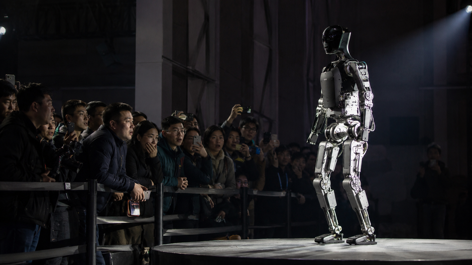 Humanoidný robot stojí na pódiu pred divákmi počas technologickej demonštrácie v Číne.
