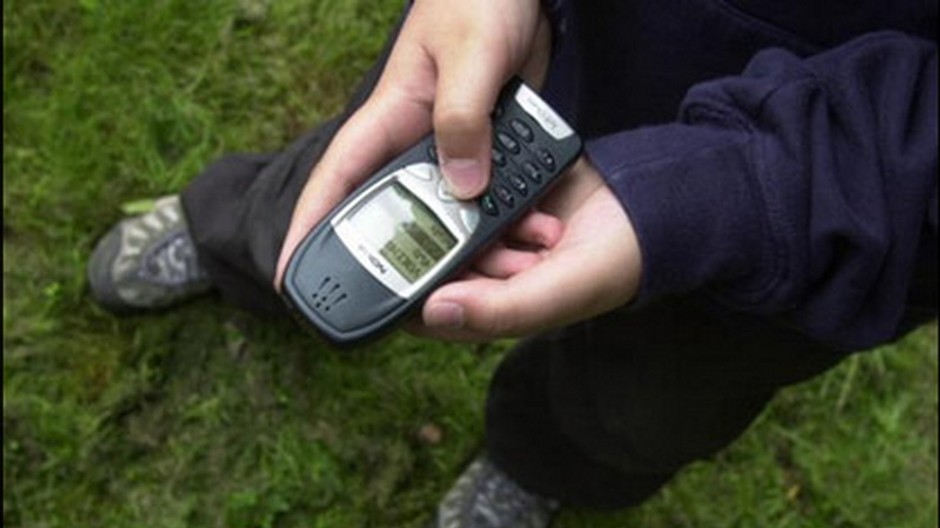 mladik s  mobilom v ruke