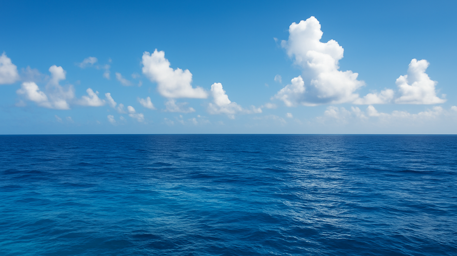 Modrý oceán pod jasnou oblohou s bielymi oblakmi – ukážka farby mora v prirodzenom svetle.