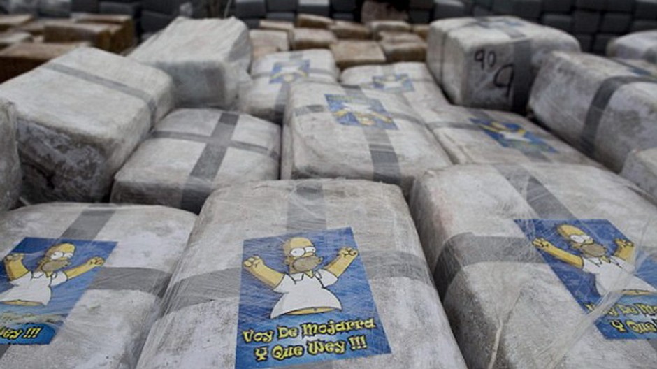 Homer Simpson pózuje na balíkoch marihuany