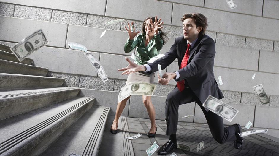 muž a žena naháňajú padajúce peniaze