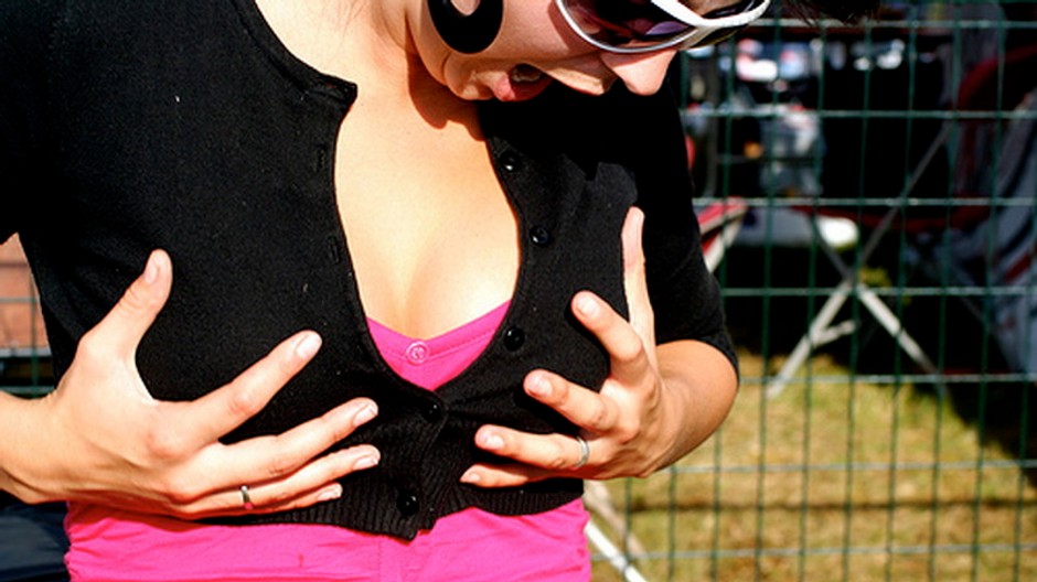 Žena si chytá prsia, kričí