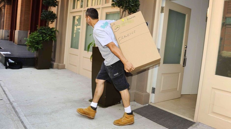 Muž krabica vynáša veci z domu exekúcia ilustračná