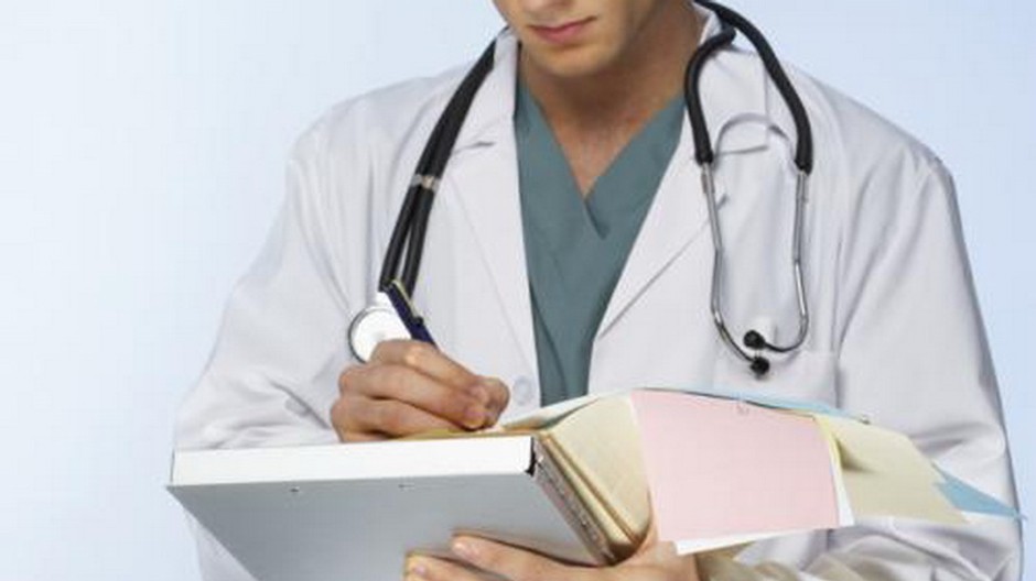 lekar v bielom drzi knihu zapisuje, svetly obrazok