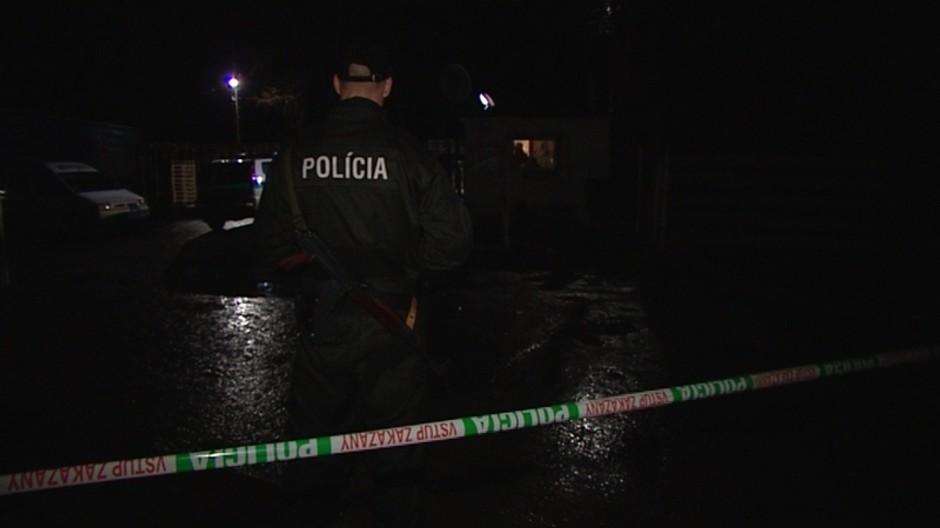 policajná páska, za ňou stojí policajt