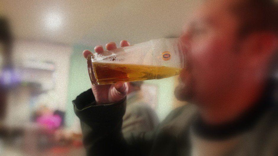 muz pije pivo rozostrena tvar