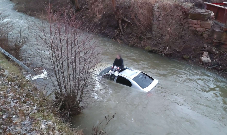 Dvadsaťročný vodič po šmyku skončil s autom v rieke. Na záchranárov čakal na streche